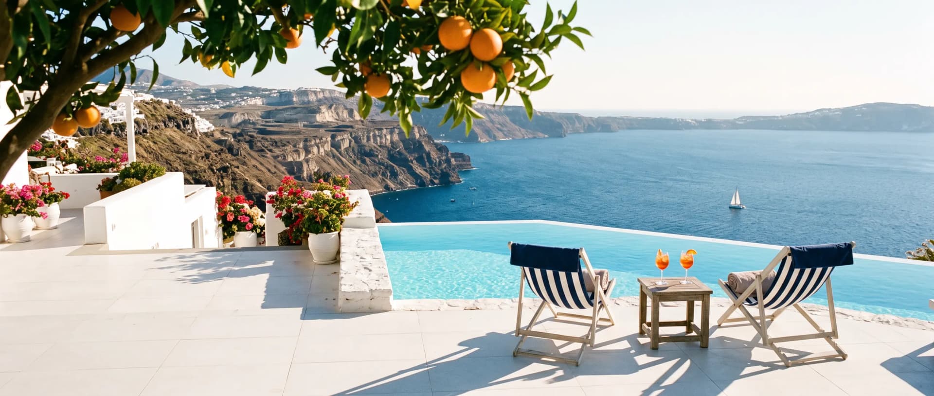 White terrace and infinity pool above a blue sea, under an orange tree